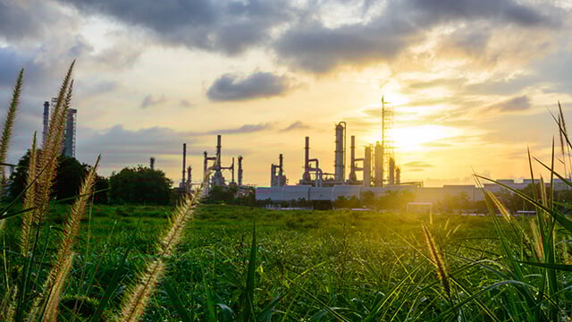 oil-refinery-green-grass-plants-sunset.jpg